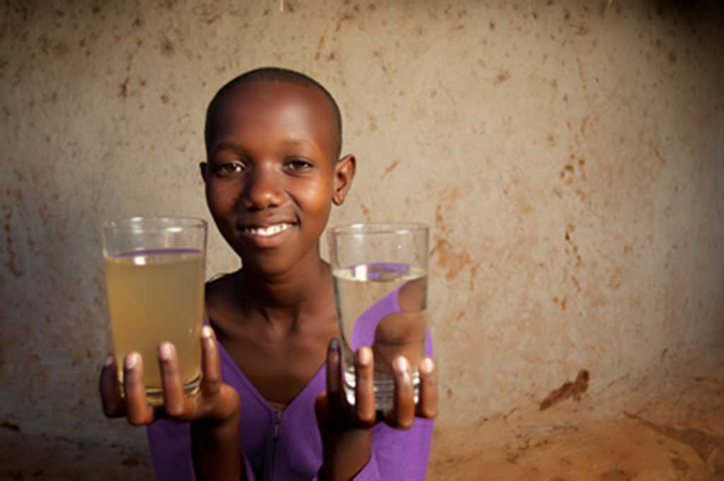 image of girl holding clean and dirty water in a glass